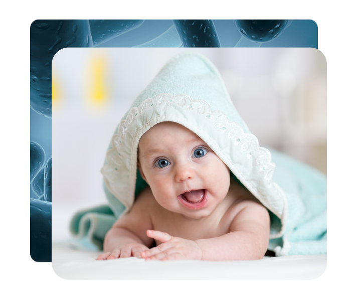 En smilende baby ligger svøbt i et hættet håndklæde, billedet ligger ovenpå en blå baggrundsgrafik med bakterieformer.
